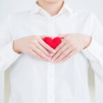 胸の前で手を重ねてハートをつくる女性