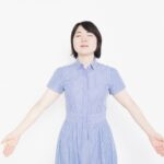 腕を広げて深呼吸する女性