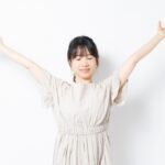 両手を大きく広げて深呼吸する女性