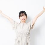 両手を広げて深呼吸する女性