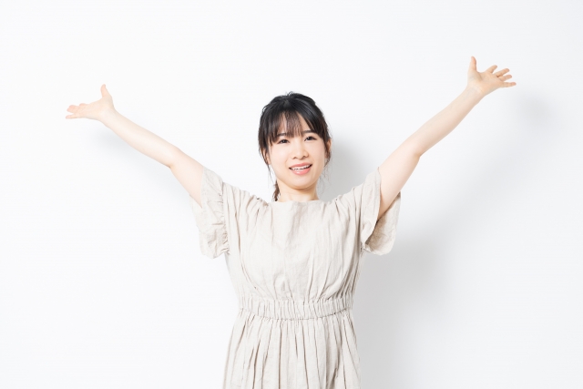 両手を広げて深呼吸する女性