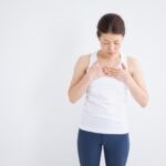 胸に手を当てて呼吸を確かめる女性