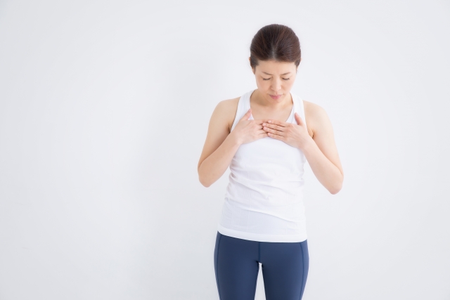 胸に手を当てて呼吸を確かめる女性