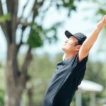 公園で腕を広げて深呼吸する男性