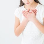 両手を胸に当てる女性