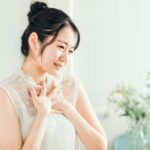 胸元を押さえて顔をしかめる女性