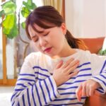 胸に手を当て息苦しそうな女性